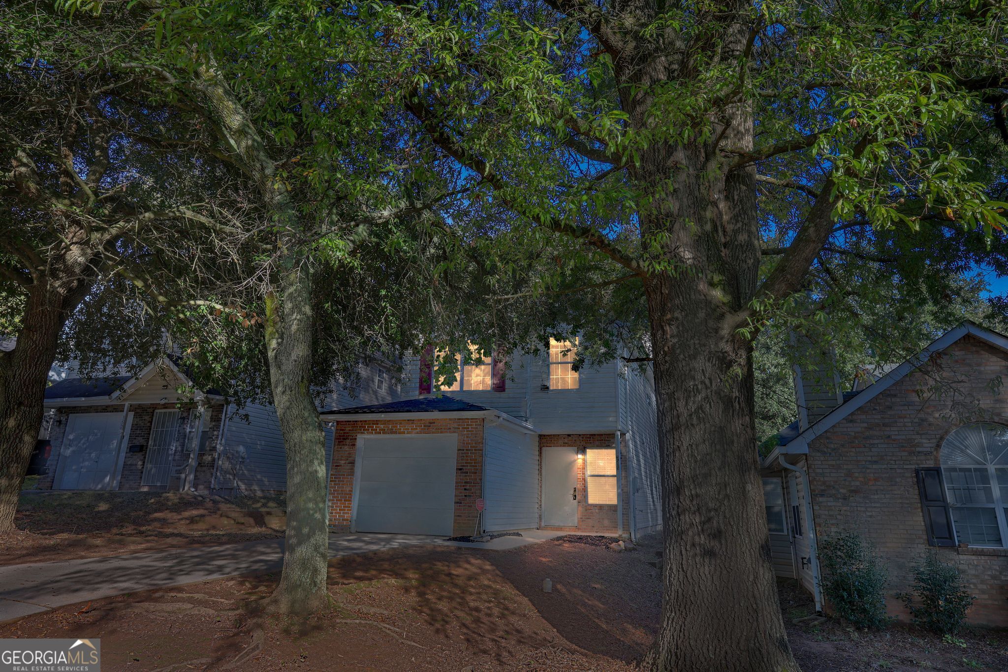a front view of a house with a yard and tree s