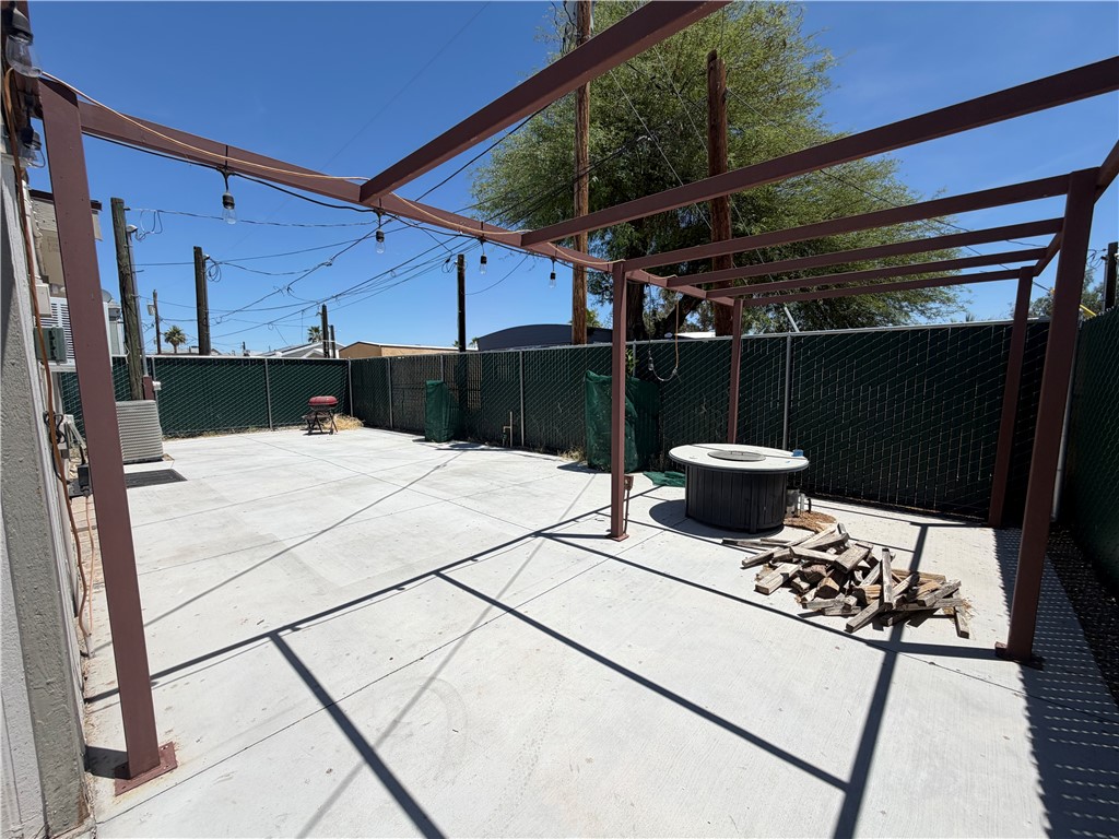 1910 Rio Grande Road Bullhead City, AZ 86442 - Photo 27 of 29 Paved outdoor area featuring a metal pergola structure, string lighting, and a built-in fire pit