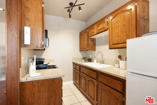 a kitchen with a sink a refrigerator and cabinets
