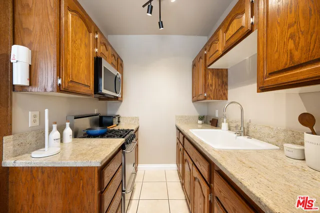 a kitchen with a sink a stove and cabinets