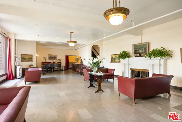 a living room with furniture kitchen view and a chandelier