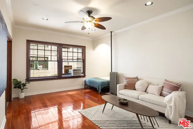 a living room with furniture and two large window