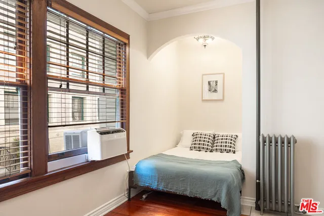 a bedroom with a bed and a large window