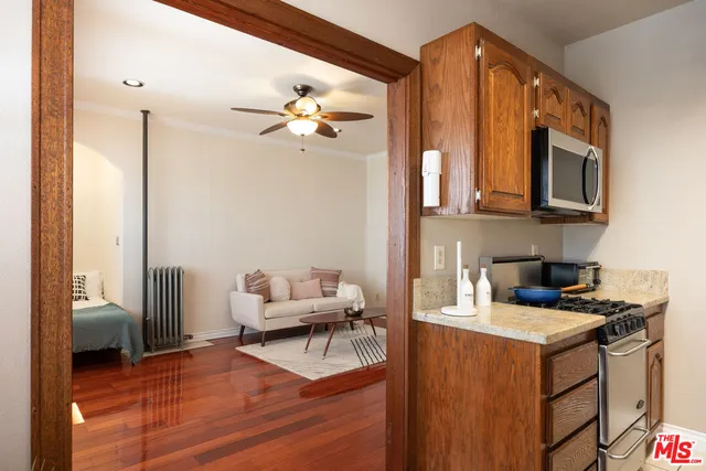 a kitchen with a stove cabinets and a living room