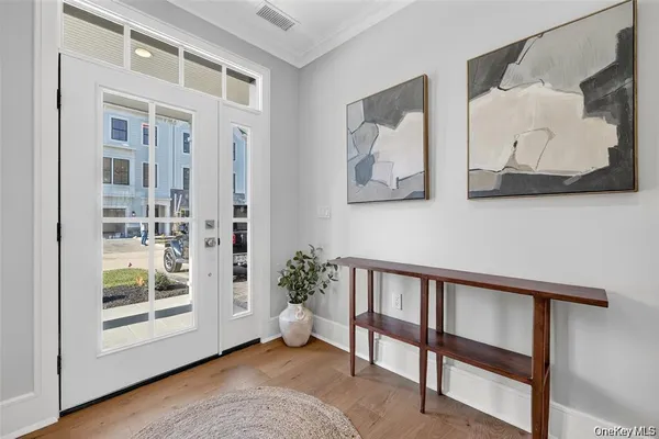 a view of a hallway with wooden floor and entryway