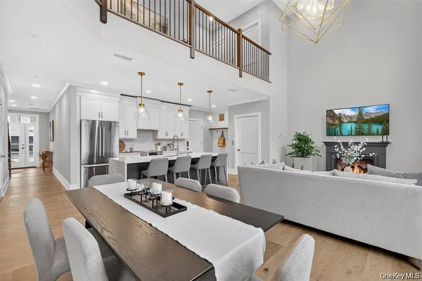 a living room with furniture kitchen view and a chandelier