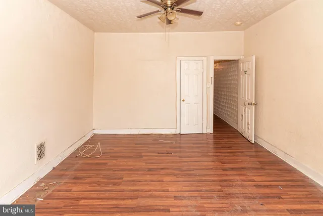 a view of a room with wooden floor and a ceiling fan