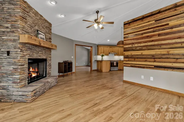 a kitchen with stainless steel appliances granite countertop a refrigerator a sink dishwasher and wooden cabinets with wooden floor