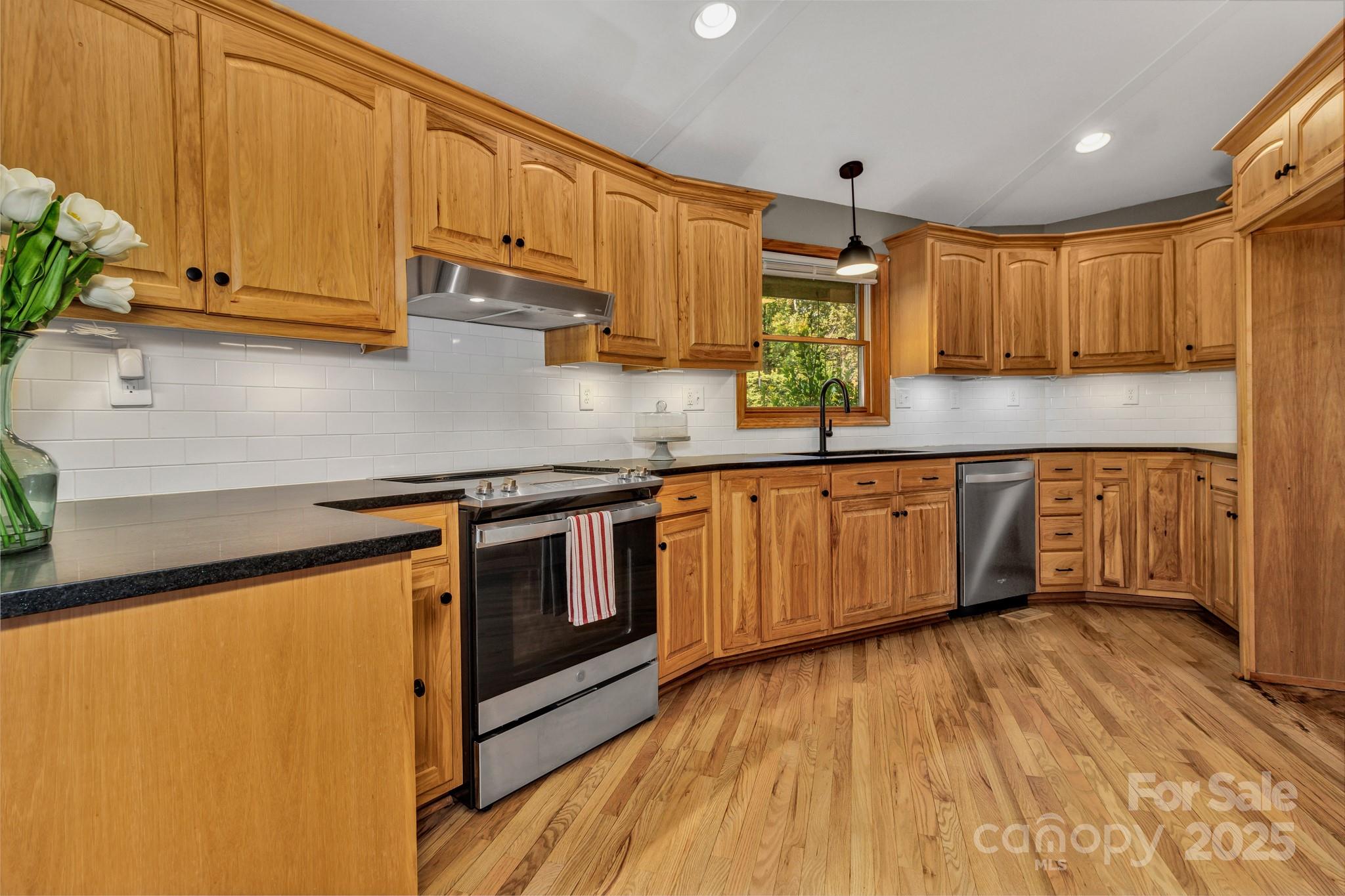 939 Morgan Hill Road Black Mountain, NC 28711 - Photo 31 of 48 a kitchen with stainless steel appliances granite countertop a sink a stove cabinets and wooden floor