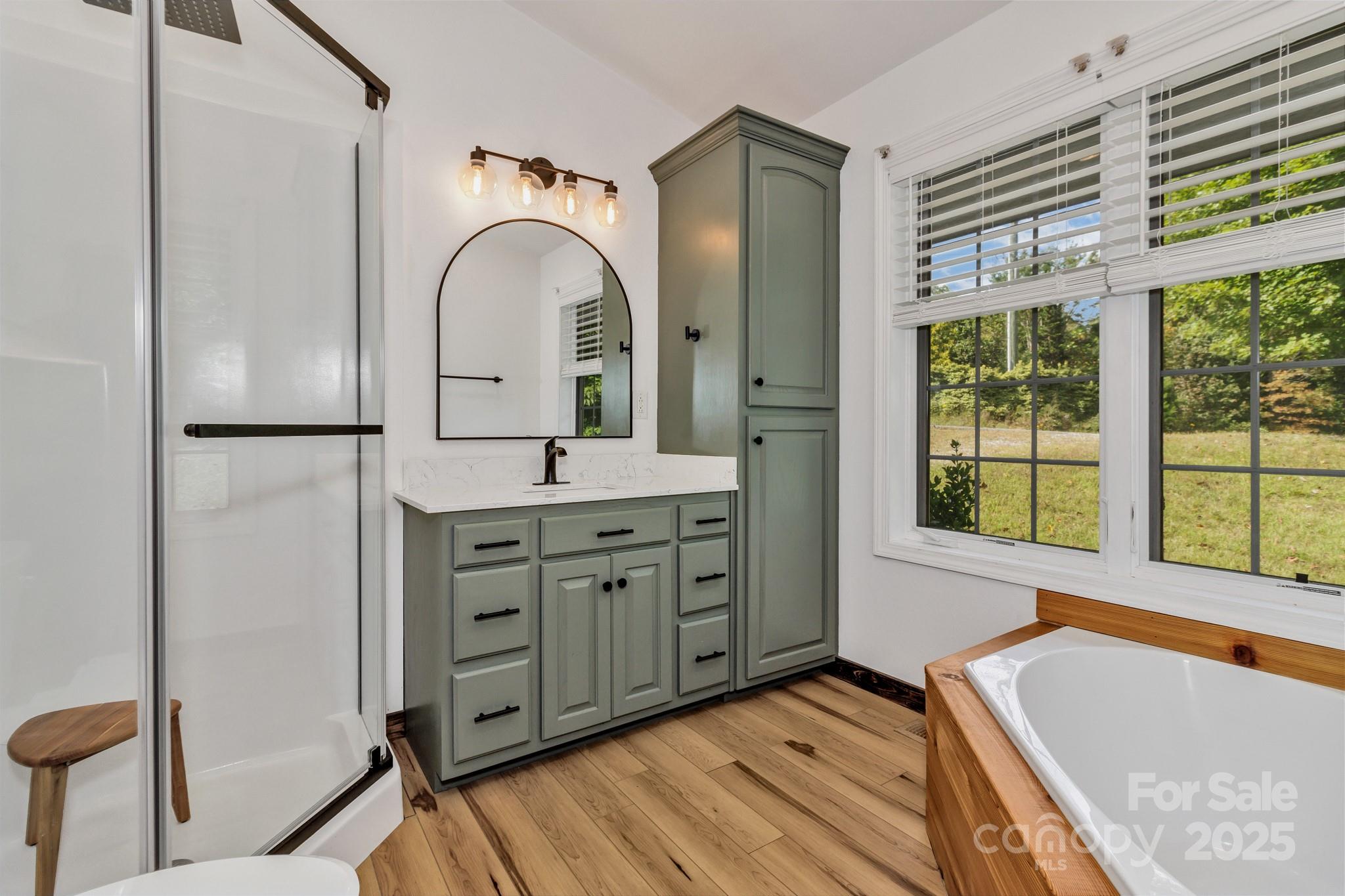 939 Morgan Hill Road Black Mountain, NC 28711 - Photo 36 of 48 a spacious bathroom with a granite countertop sink mirror and a bathtub