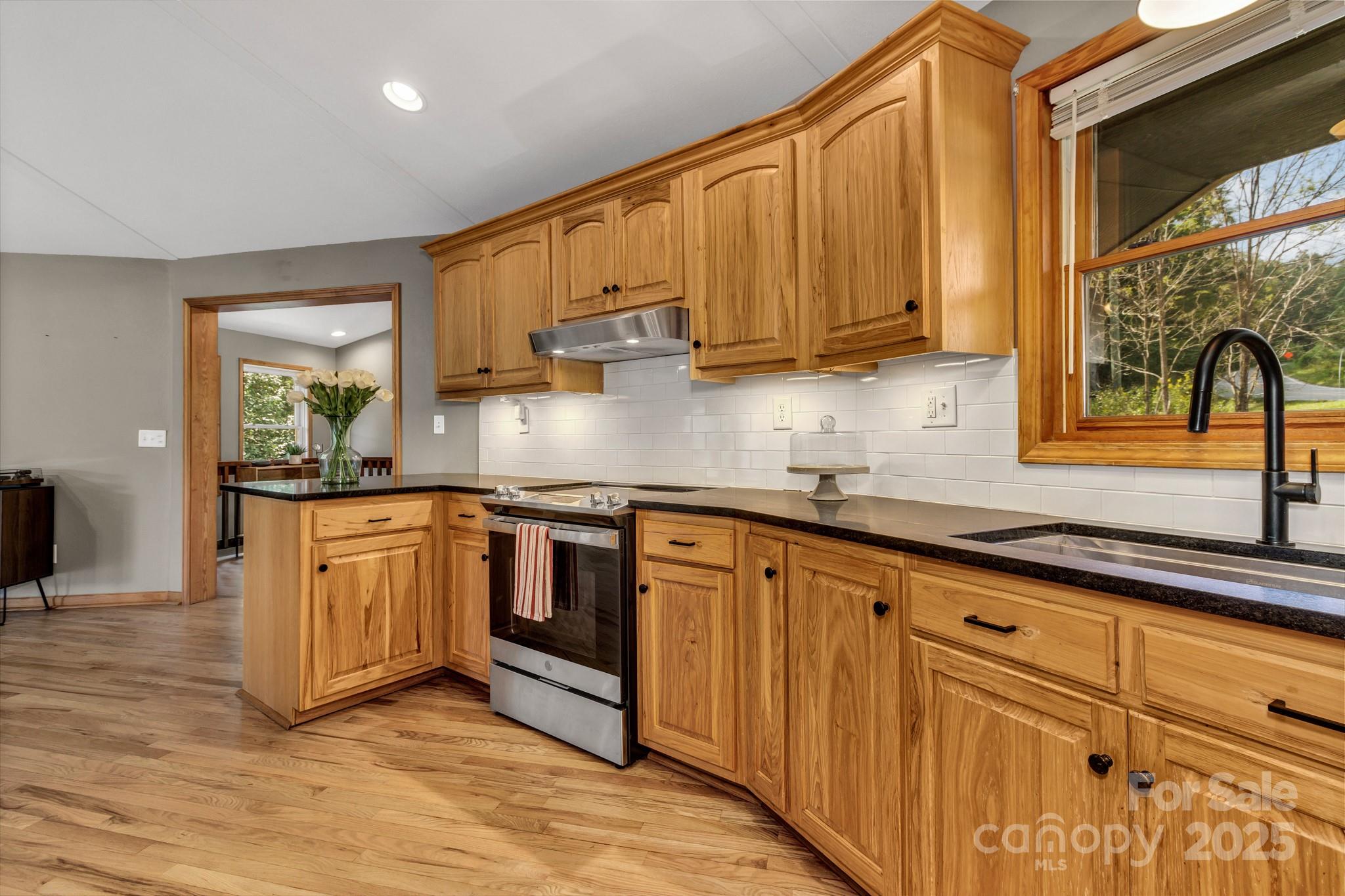 939 Morgan Hill Road Black Mountain, NC 28711 - Photo 4 of 48 a kitchen with stainless steel appliances granite countertop a stove a sink and a granite counter tops with wooden floors
