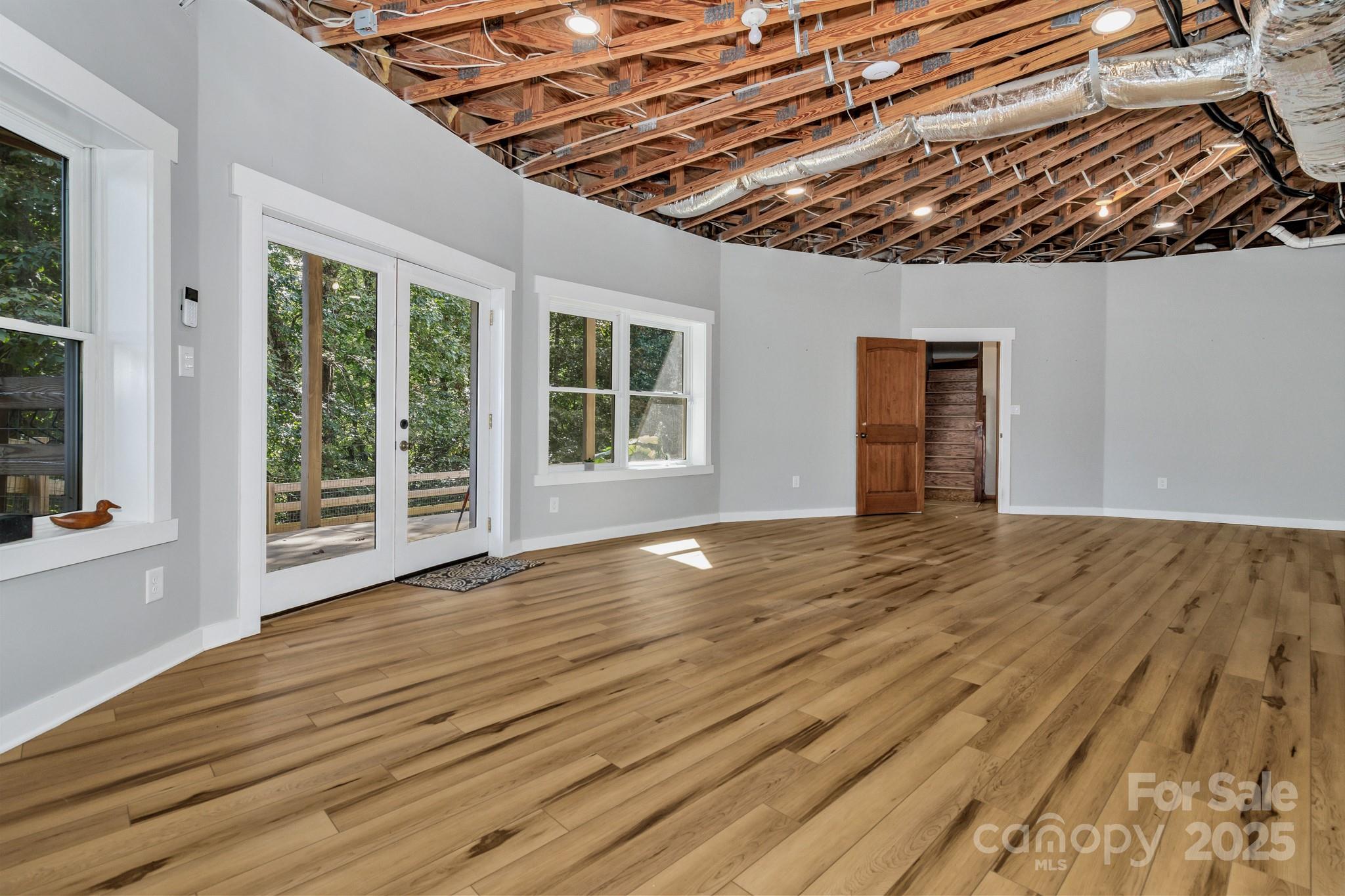 939 Morgan Hill Road Black Mountain, NC 28711 - Photo 43 of 48 a view of an empty room with wooden floor and a window