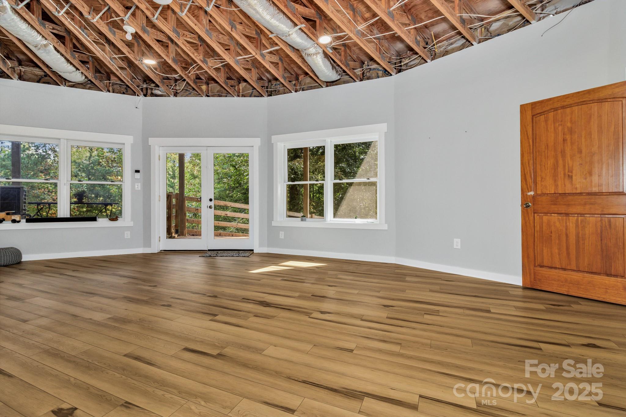 939 Morgan Hill Road Black Mountain, NC 28711 - Photo 45 of 48 a view of an empty room with wooden floor and a window