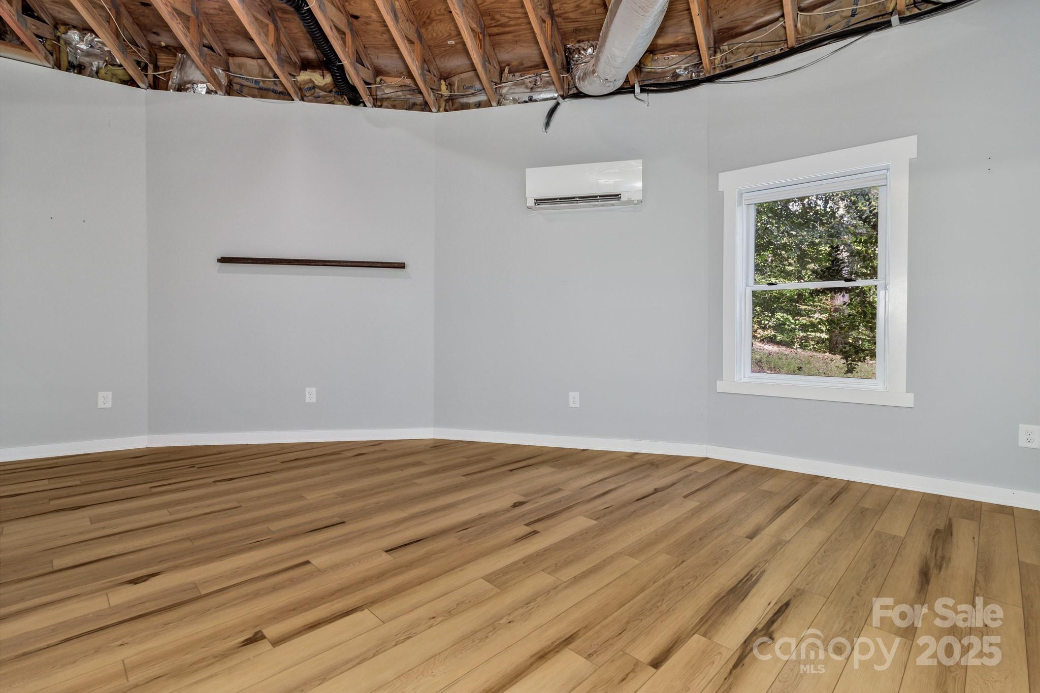 939 Morgan Hill Road Black Mountain, NC 28711 - Photo 46 of 48 a view of an empty room with wooden floor and a window