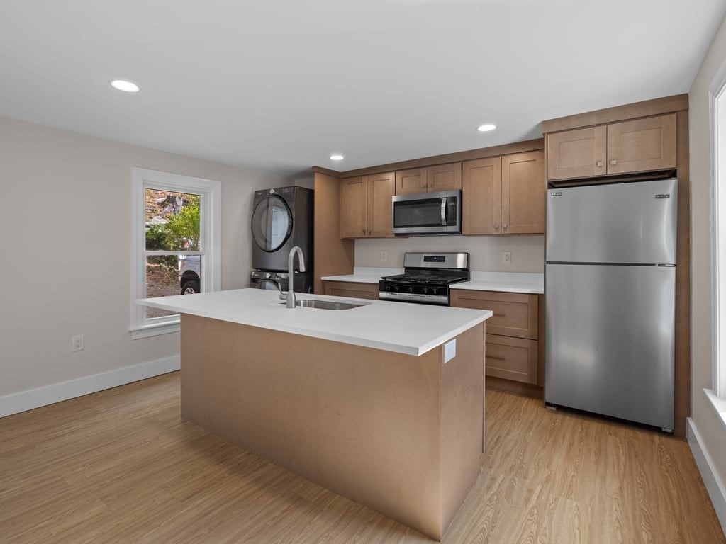 40 Cedar Street Wellesley, MA 02481 - Photo 4 of 23 a kitchen with kitchen island a refrigerator a stove a sink and a microwave