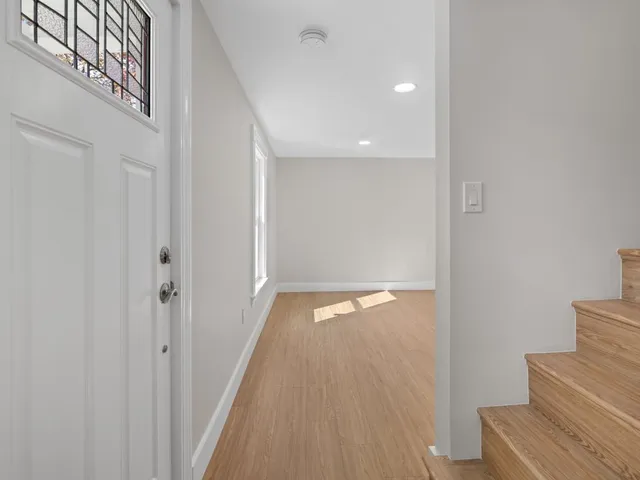 a view of a hallway with wooden floor and staircase