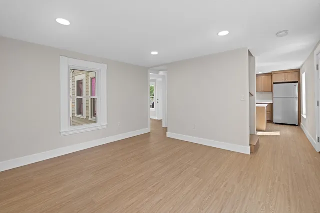 a view of a room with wooden floor and a window