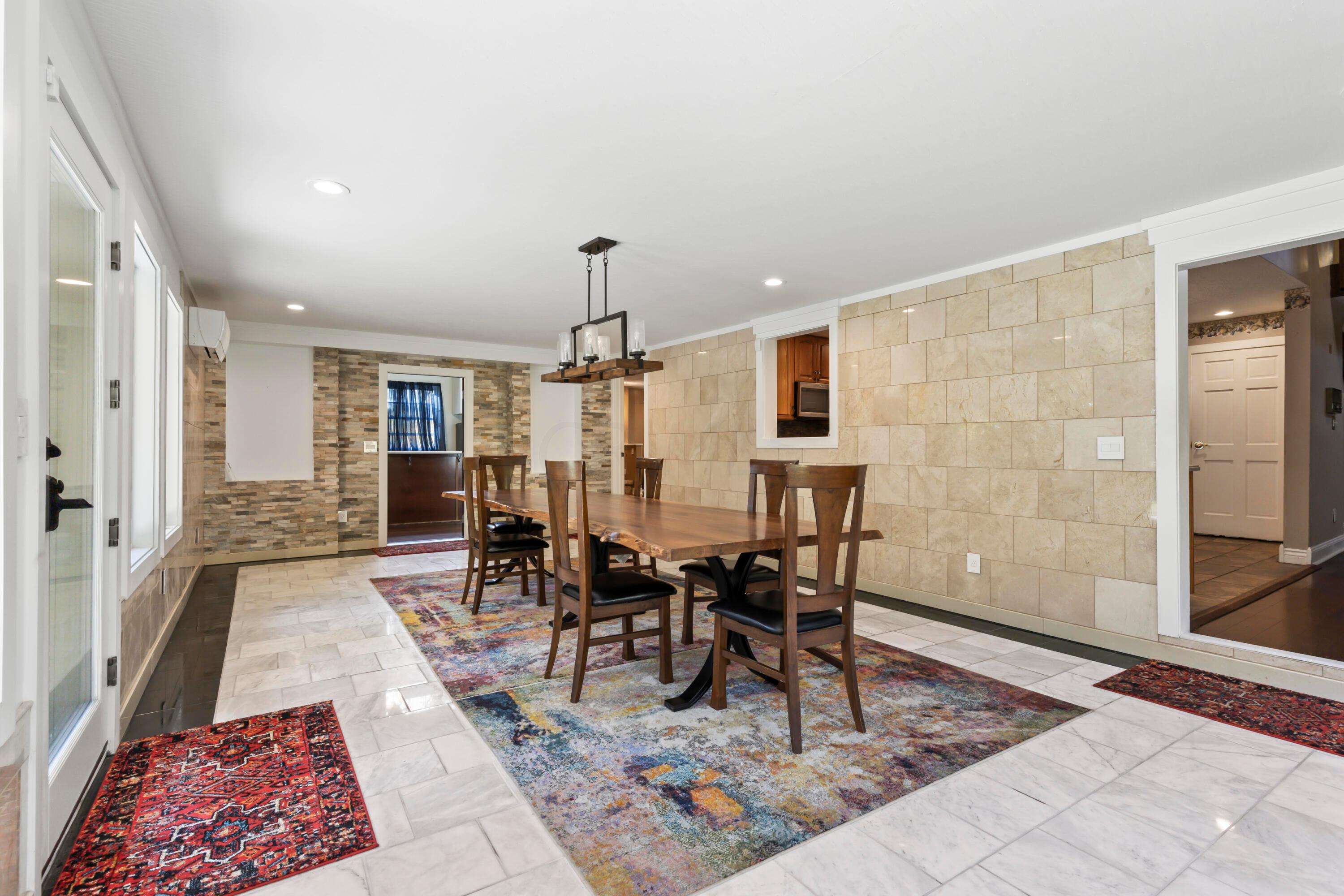 9495 Kilbourne Road Sunbury, OH 43074 - Photo 5 of 84 • New marble & granite flooring
~2021
• Can lighting
• Italian chandelier
• Wall of windows faces
rear yard & woods
• Access to Master Bedroom
• Door to rear yard
• Live edge table is negotiable
• New windows ~ 2021
• Stone accent wall with art
niches
• New door to In-Law Suite
• New splite HVAC system
~ 2021