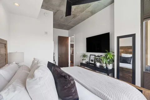 a bedroom with a bed and a flat screen tv