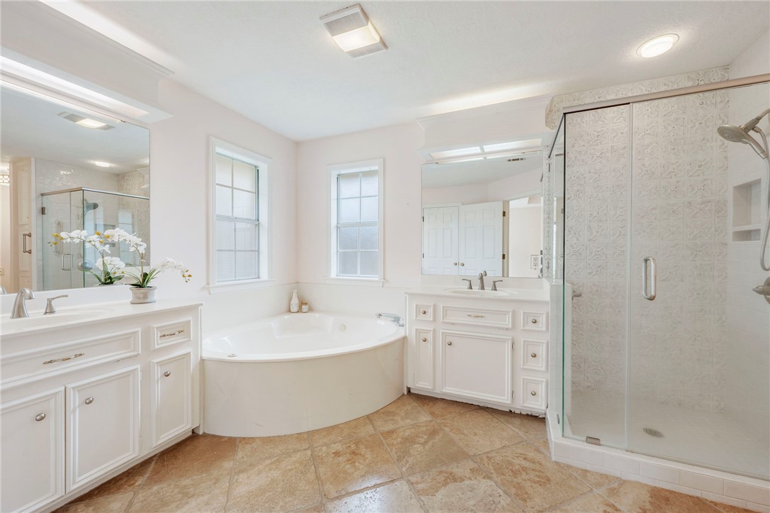 713 Willow Loop College Station, TX 77845 - Photo 18 of 39 a bathroom with a tub a sink shower and mirror