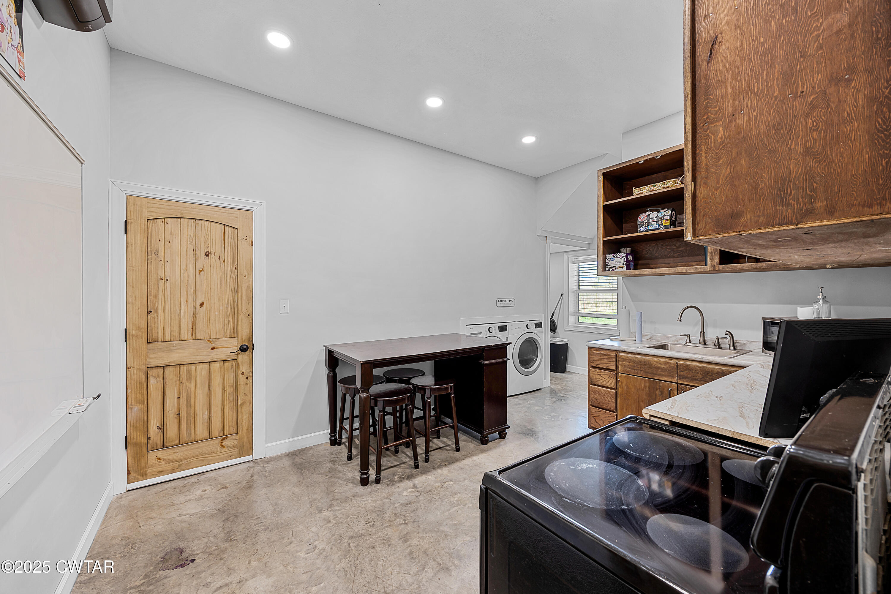 90 Dawson Bottom Road Humboldt, TN 38343 - Photo 10 of 24 a kitchen with stainless steel appliances granite countertop a stove top oven a sink a dining table and chairs with wooden floor