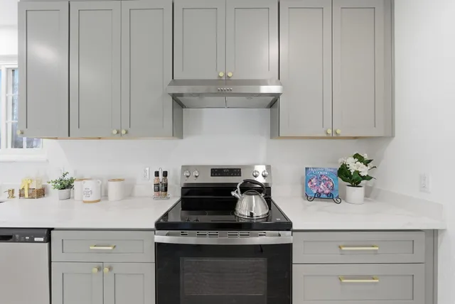 a kitchen with granite countertop white cabinets and white appliances