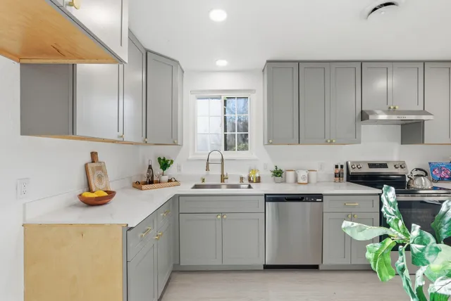 a kitchen with a sink a stove and cabinets