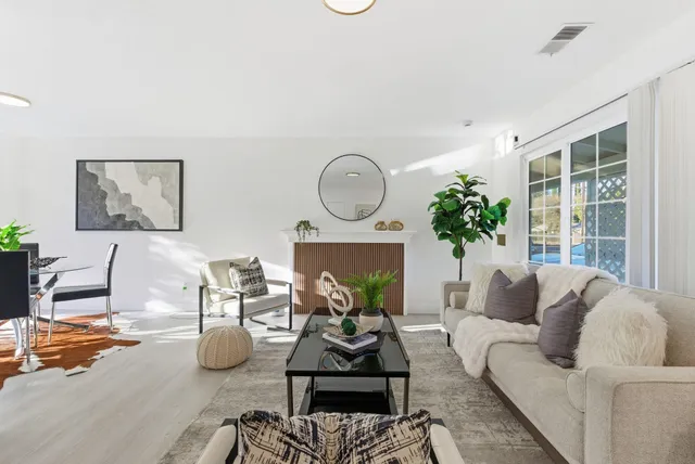 a living room with furniture flowerpot and wooden floor