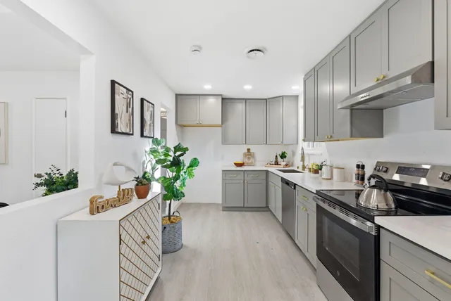 a kitchen with a white stove top oven and white cabinets
