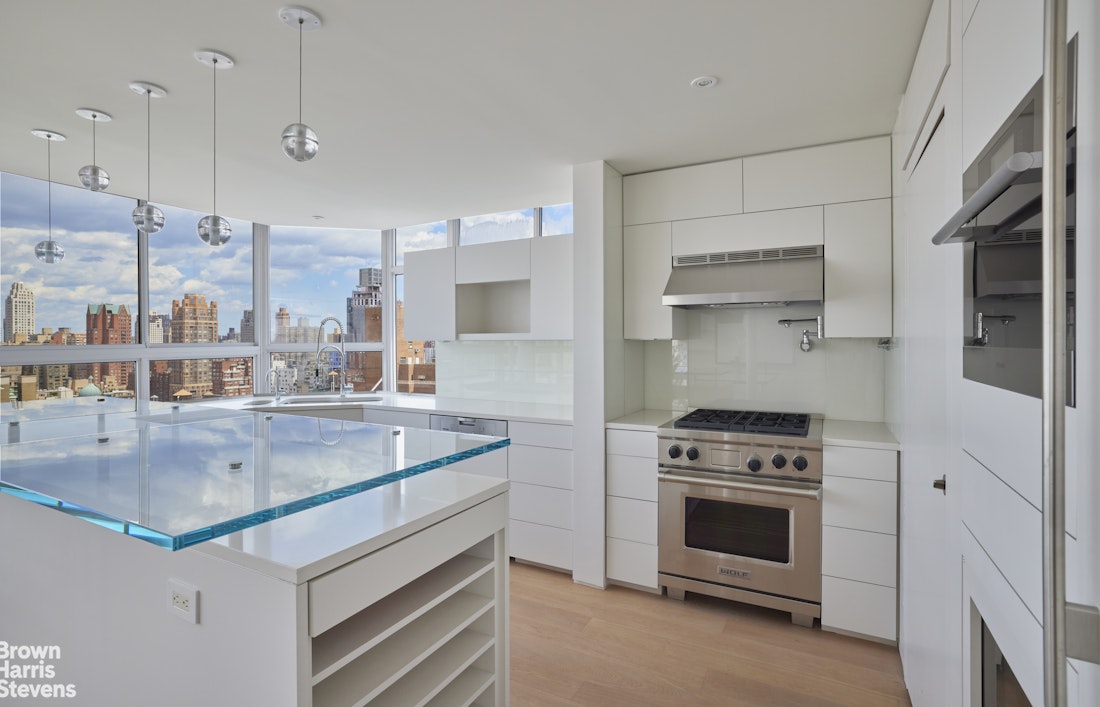 110 East 71st Street, Unit 19 Manhattan, NY 10021 - Photo 4 of 15 a kitchen with stainless steel appliances granite countertop a stove and a sink