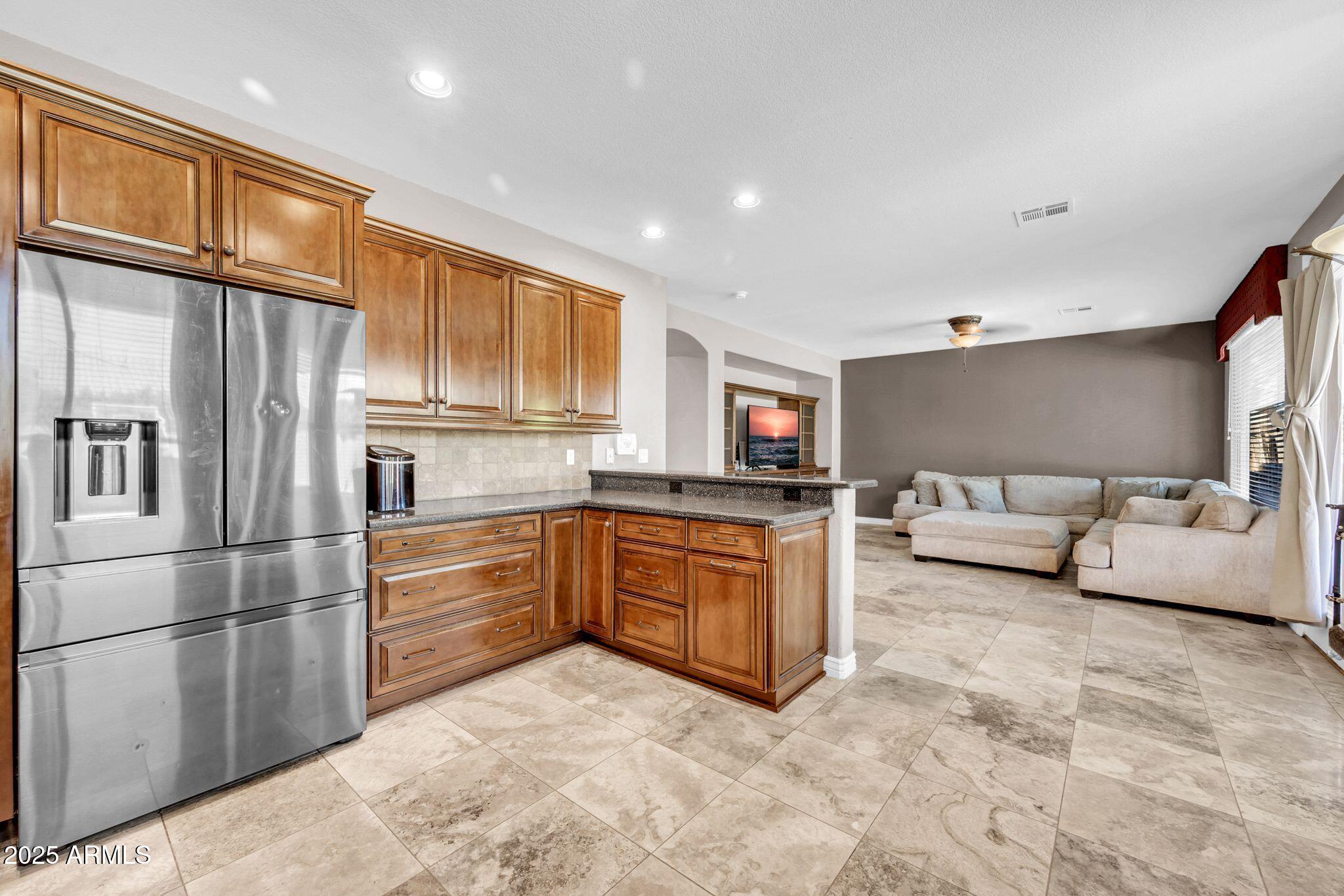1302 West Winchester Way Chandler, AZ 85224 - Photo 14 of 61 a kitchen with granite countertop a refrigerator and cabinets