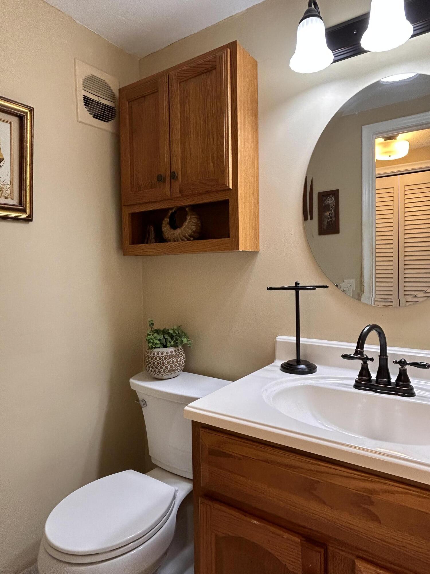 680 Horizon West, Unit 103 Boynton Beach, FL 33435 - Photo 11 of 61 a bathroom with a toilet sink and mirror