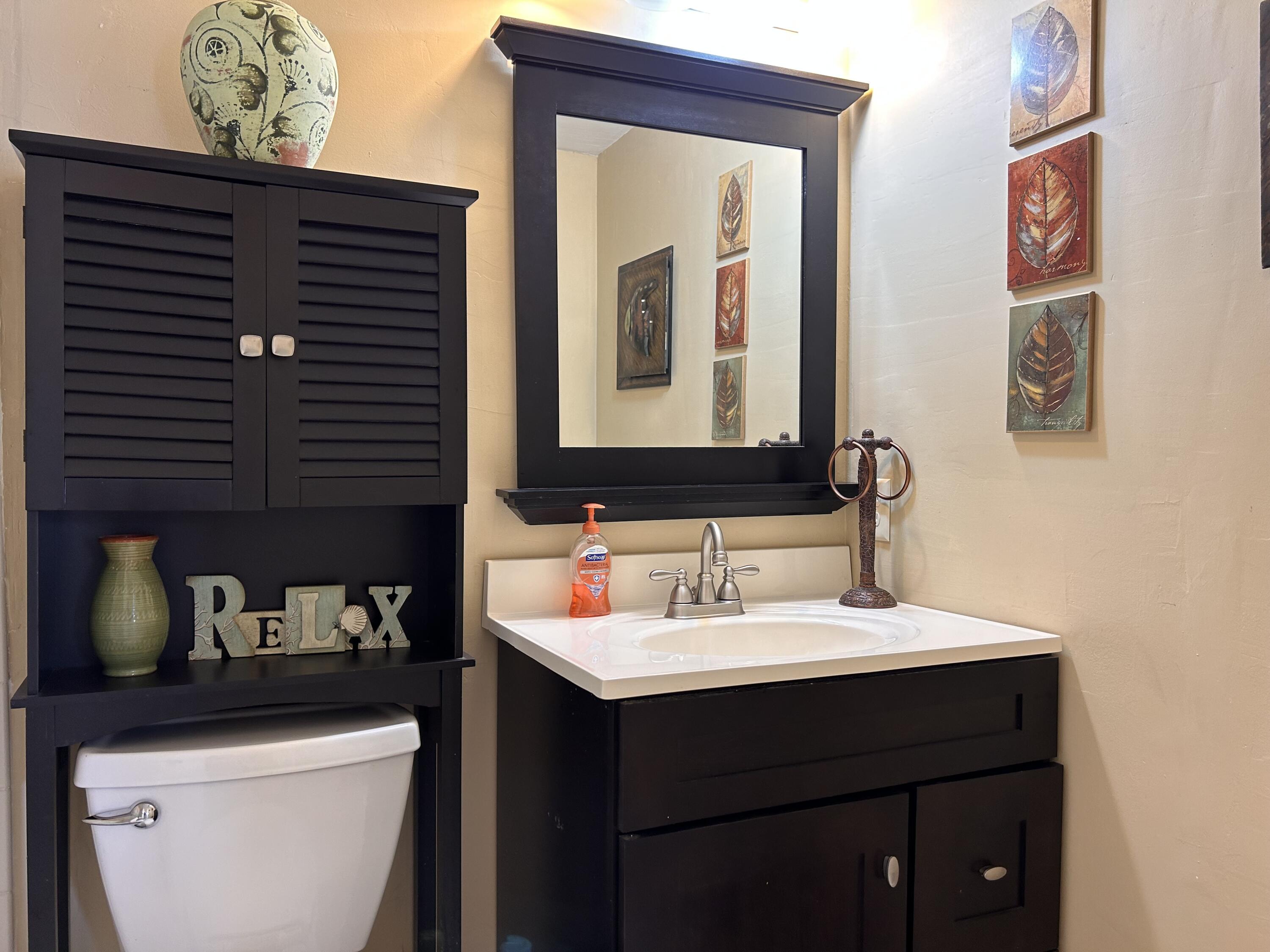 680 Horizon West, Unit 103 Boynton Beach, FL 33435 - Photo 19 of 61 a bathroom with a sink a toilet and a mirror