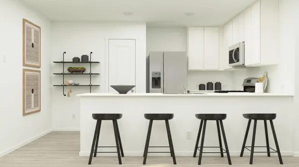 a kitchen with stainless steel appliances granite countertop white cabinets and chair