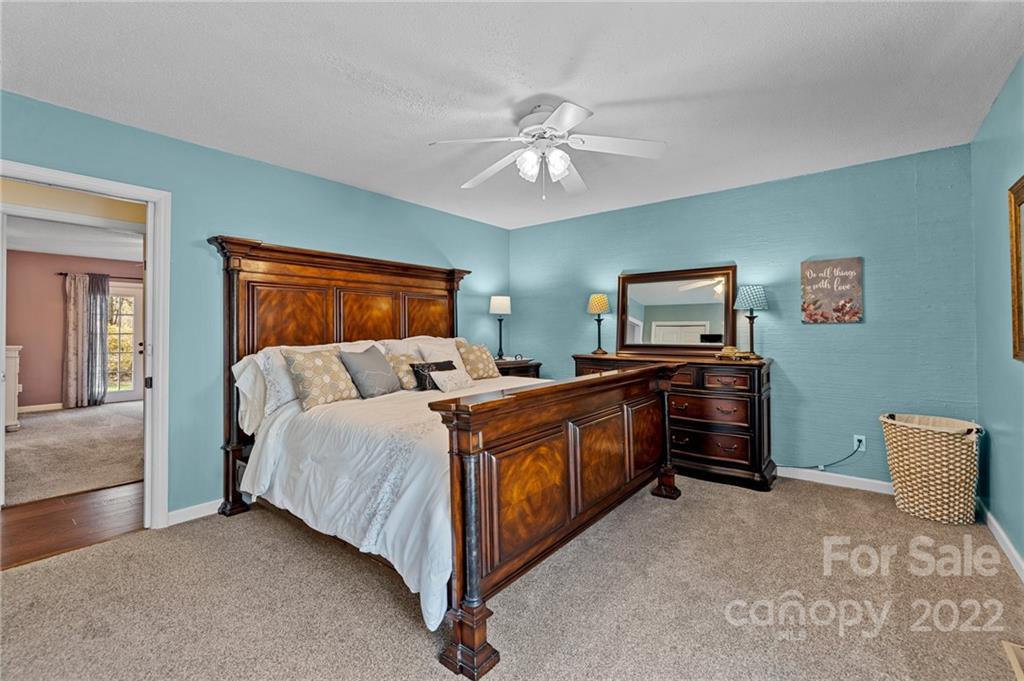 8241 Fairfield Forest Road Denver, NC 28037 - Photo 23 of 48 a bed room with a bed and a chandelier