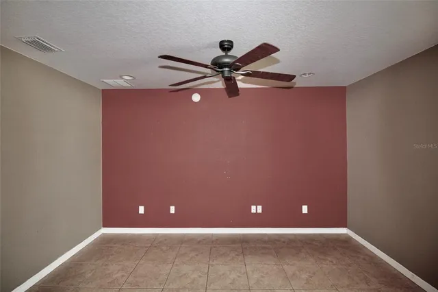a view of a room with a ceiling fan and a window