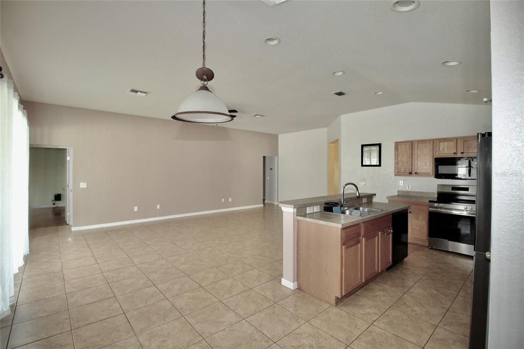 5739 Southwest 40th Street Ocala, FL 34474 - Photo 17 of 52 a kitchen with stainless steel appliances granite countertop a stove and a sink