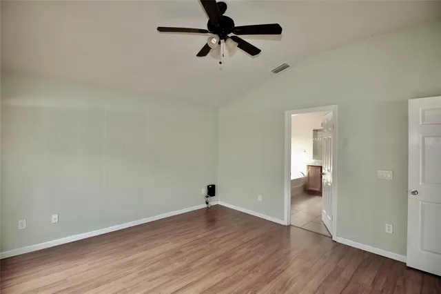 a view of a room with wooden floor and a ceiling fan