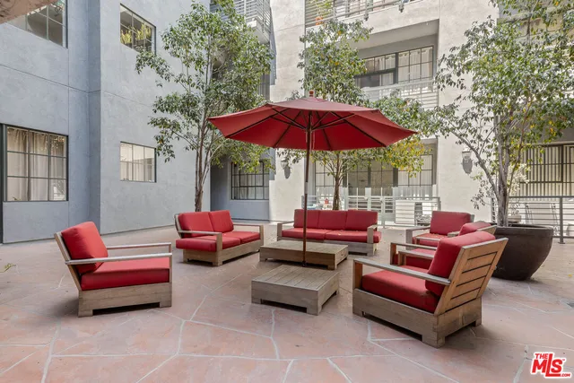 a outdoor living space with furniture and red umbrella