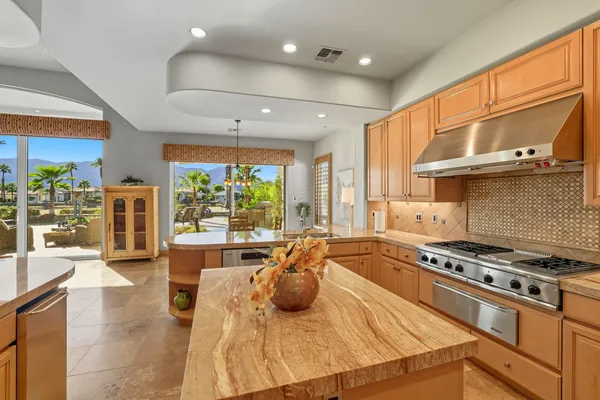 a kitchen with stainless steel appliances granite countertop a stove a sink and a refrigerator