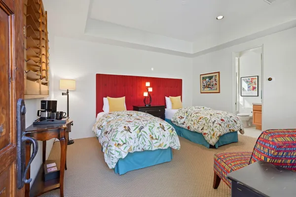 a bedroom with two beds and a chair