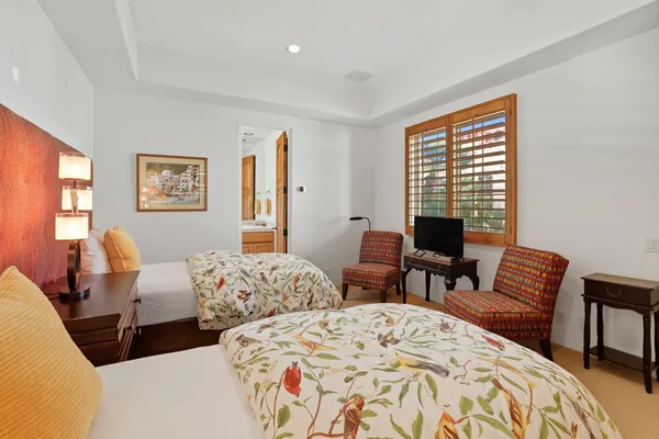 a bedroom with two beds and a large window