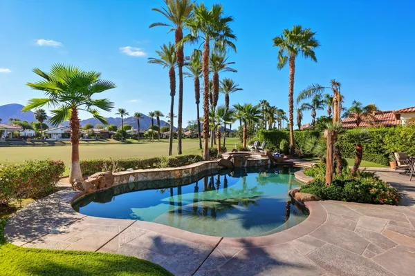 a view of a house with backyard swimming pool and sitting area