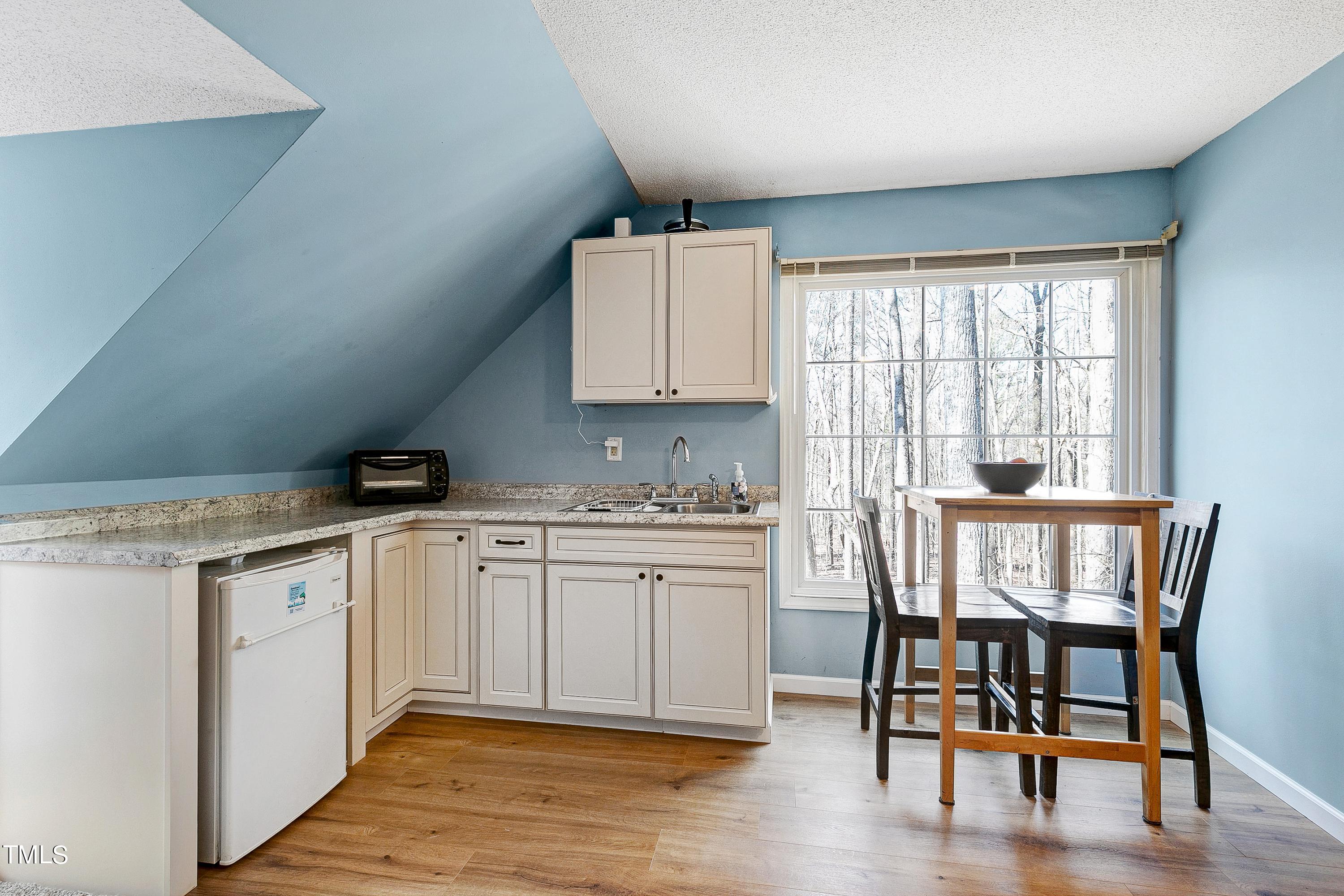 10021 Sycamore Road Raleigh, NC 27613 - Photo 29 of 40 a kitchen with sink cabinets and dining table chair