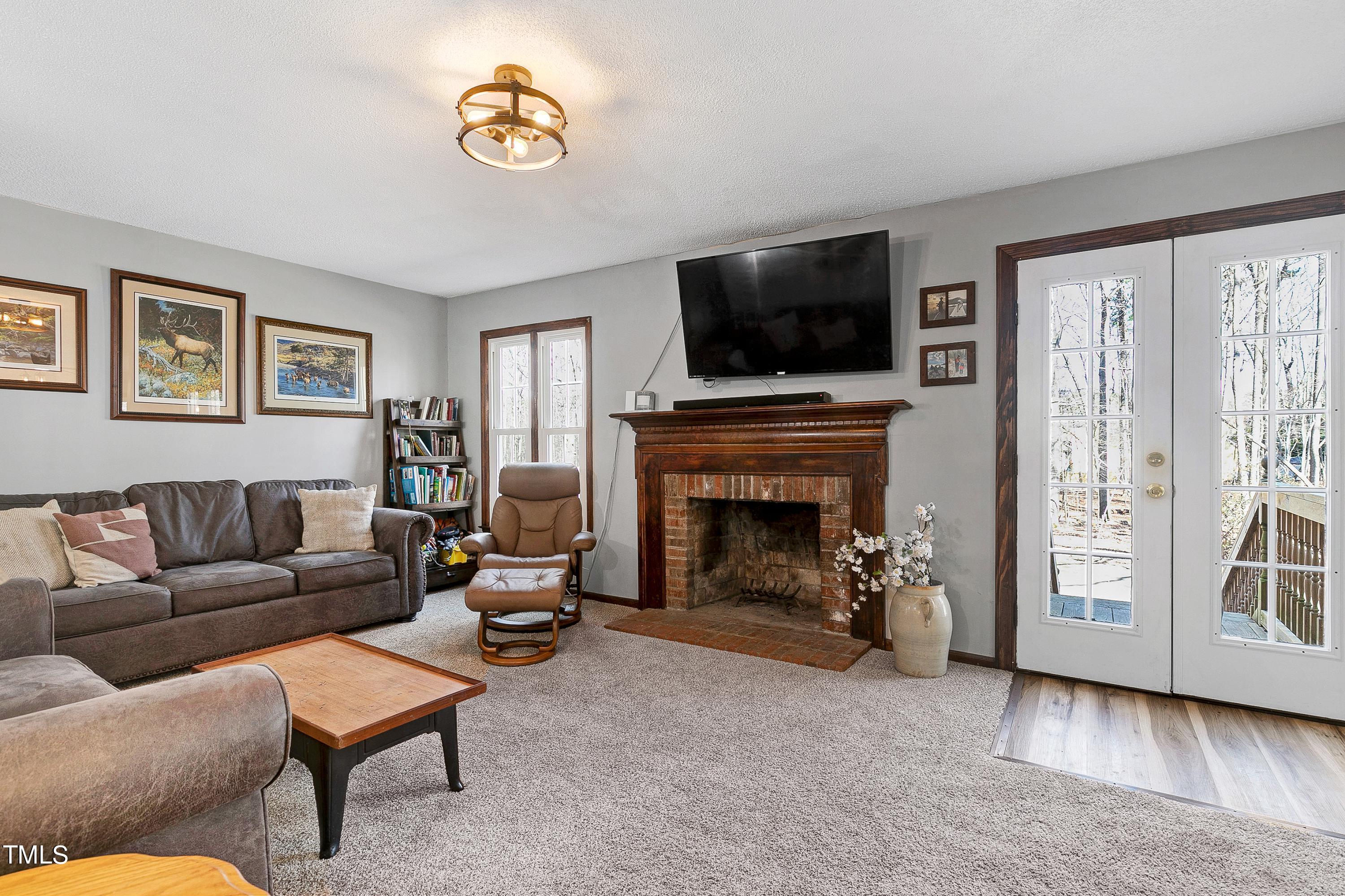 10021 Sycamore Road Raleigh, NC 27613 - Photo 7 of 40 a living room with furniture a flat screen tv and a fireplace