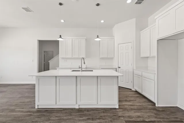 a kitchen with kitchen island white cabinets and stainless steel appliances