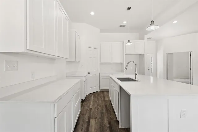 a kitchen with a sink stove and cabinets