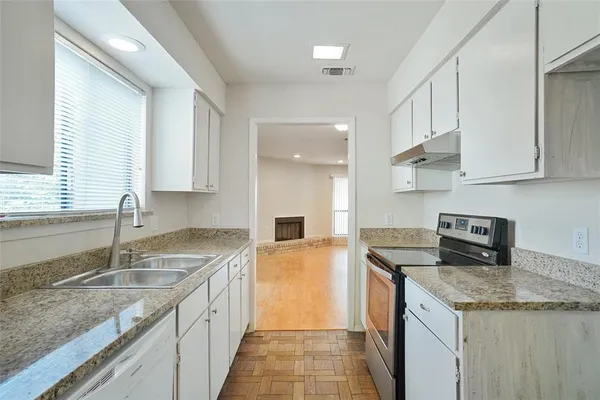 a kitchen with granite countertop kitchen island a sink stove and cabinets