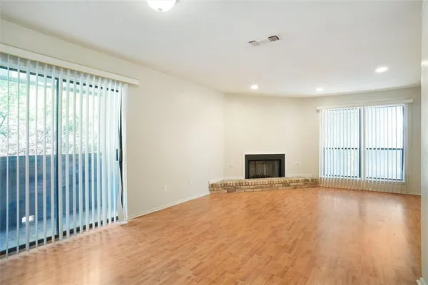 a view of a livingroom with wooden floor and a fireplace