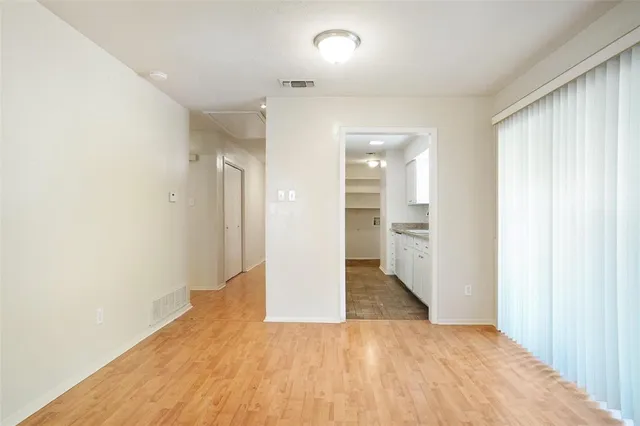 a view of a room with wooden floor and a bathroom